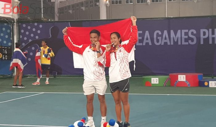 Petenis ganda campuran Indonesia, Christopher Rungkat/Aldila Sutjiadi, berpose dengan medali emas SEA Games 2019 di Rizal Memorial Tennis Center, Manila, Sabtu (7/12/2019).