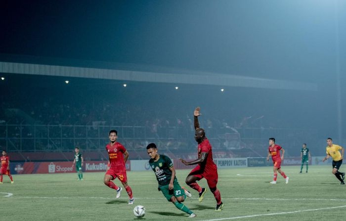 Gelandang Persebaya Surabaya, Fandi Eko Utomo, mendapatkan pengawalan dari bek Kalteng Putra, OK John, pada laga pekan ke-18 Liga 1 2019