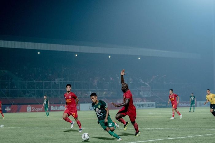 Gelandang Persebaya Surabaya, Fandi Eko Utomo, mendapatkan pengawalan dari bek Kalteng Putra, OK John, pada laga pekan ke-18 Liga 1 2019