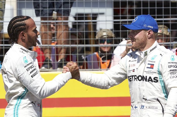 Duo Mercedes, Lewis Hamilton (kiri) dan Valtteri Bottas (kanan), berjabat tangan seusai melakoni sesi kualifikasi F1 GP Prancis 2019, Sabtu (22/6/2019)