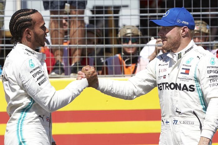 Duo Mercedes, Lewis Hamilton (kiri) dan Valtteri Bottas (kanan), berjabat tangan seusai melakoni sesi kualifikasi F1 GP Prancis 2019, Sabtu (22/6/2019)