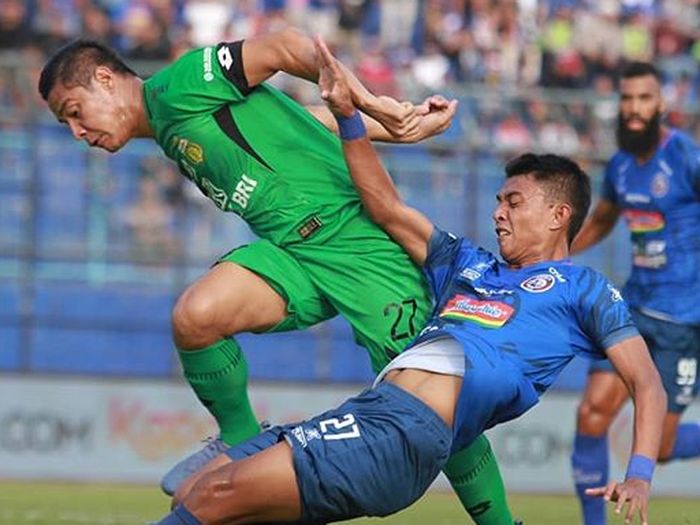 Striker Arema FC, Dedik Setiawan, mendapatkan pengawalan ketat dari bek Bhayangkara FC, Indra Kahfi, pada laga pekan ke-11 Liga 1 2019
