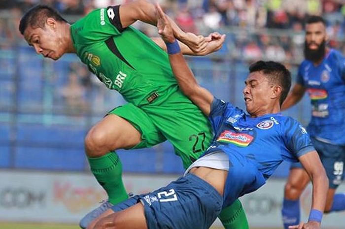 Striker Arema FC, Dedik Setiawan, mendapatkan pengawalan ketat dari bek Bhayangkara FC, Indra Kahfi, pada laga pekan ke-11 Liga 1 2019