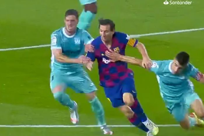 Kapten Barcelona, Lionel Messi, ditarik oleh bek Leganes, Jonathan Silva, dalam laga Liga Spanyol di Stadion Camp Nou, Selasa (16/6/2020).