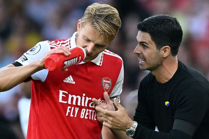 Pelatih Arsenal, Mikel Arteta, berbicara dengan Mikel Odegaard.