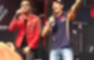 Pebalap Repsol Honda asal Spanyol, Marc Marquez (kanan), bernyanyi dengan vokalis band Nidji dalam a
