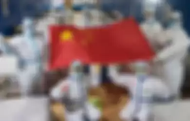 Sejumlah tenaga media di Wuhan, Hubei,   berpose dengan membentangkan bendera China di sebuah tempat perawatan yang sudah tanpa pasien Covid-19.