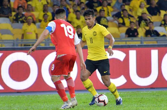 Penyerang timnas Malaysia, Safawi Rasid yang mencoba melewati bek sekaligus kapten timnas Tajikistan, Ahtam Nazarov pada laga uji coba di Stadion Nasional Bukit Jalil, Kuala Lumpur, 9 November 2019.  