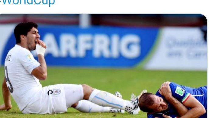 Striker Uruguay memegangi giginya usai menggigit bek Italia, Giorgio Chiellini, pada Piala Dunia 2014