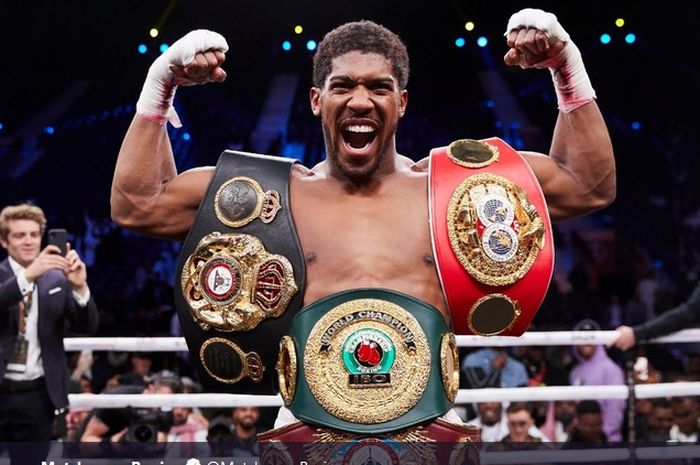 Petinju kelas berat, Anthony Joshua memamerkan berbagai gelarnya. Gelar tersebut antara lain IBF, IBO, WBO, dan WBA.