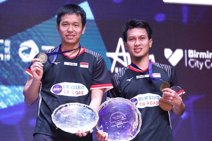 Pasangan ganda putra Indonesia, Mohammad Ahsan/Hendra Setiawan, berpose dengan medali dan trofi juara All England Open 2019 di atas podium kampiun di Arena Birmingham, Birmingham, Inggris, Minggu (10/3/2019).