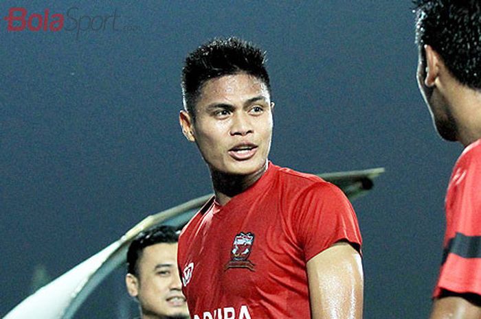   Pemain belakang Madura United, Fachruddin Aryanto (tengah), berbicara dengan rekan setimnya usai l