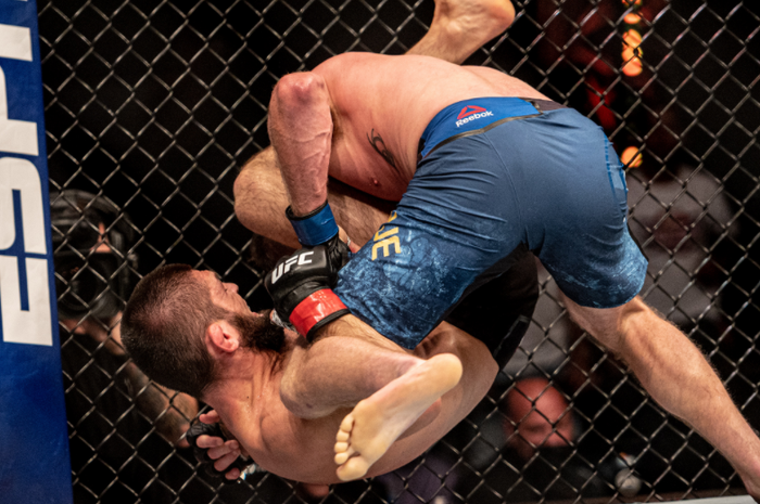 Jurus Khabib Nurmagomedov (bawah) kala mencekik Justin Gaethje (atas) pada UFC 254 (25/10/2020).