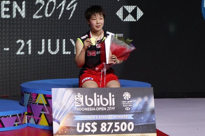 Pebulu tangkis tunggal putri Jepang, Akane Yamaguchi, berpose di podium kampiun Indonesia Open 2019 setelah memenangi laga final atas Pusarla Venkata Sindhu (India) di Istora Senayan, Jakarta, Minggu (21/7/2019).