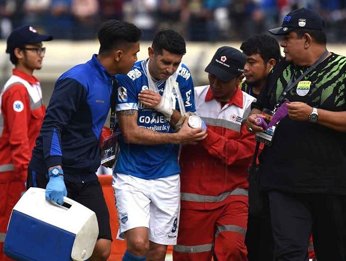 Esteban Vizcarra dibawa keluar lapangan sambil meringis kesakitan karena cedera saat Persib Bandung menjamu Arema  FC dalam leg pertama babak 16 besar Piala Indonesia di Stadion Si Jalak Harupat, Kabupaten Bandung, Senin (18/2/2019) sore WIB.