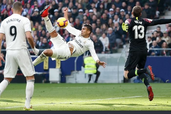 Pemain Real Madrid, Casemiro, melakukan gol salto ke gawang Atletico Madrid dalam laga di Wanda Metropolitano, Sabtu (9/2/2019)