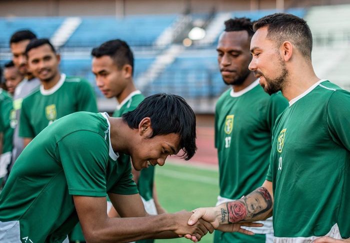 Mochamad Supriadi bersalaman dengan para pemain Persebaya di sesi latihan, Senin (20/5/2019).