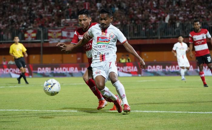 Duel gelandang Madura United, Syahrian Abimanyu (belakang) dengan pemain Persija Jakarta, Ramdani Lestaluhu, di Stadion Gelora Ratu Pamelingan, Pamekasan, Madura, Jumat (16/8/2019).