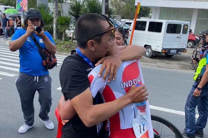 Pembalap sepeda putra Indonesia, Aiman Cahyadi, memeluk ofisial PB ISSI setelah memastikan diri meraih medali emas dari nomor individual time trial men elite pada SEA Games 2019.