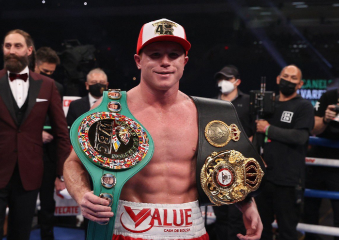 Petinju kelas menengah super, Canelo Alvarez, saat memamerkan sabuk juara WBA dan WBC.